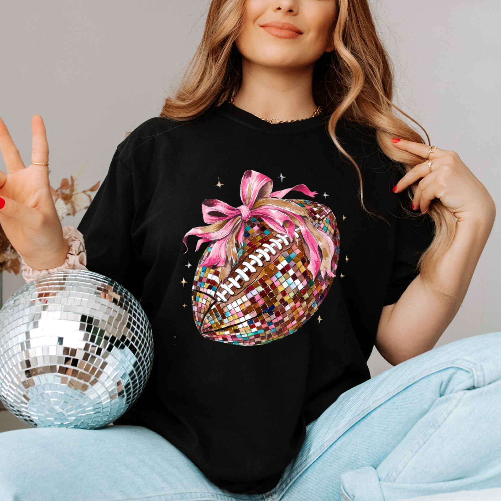 a woman wearing a black shirt with a football on it