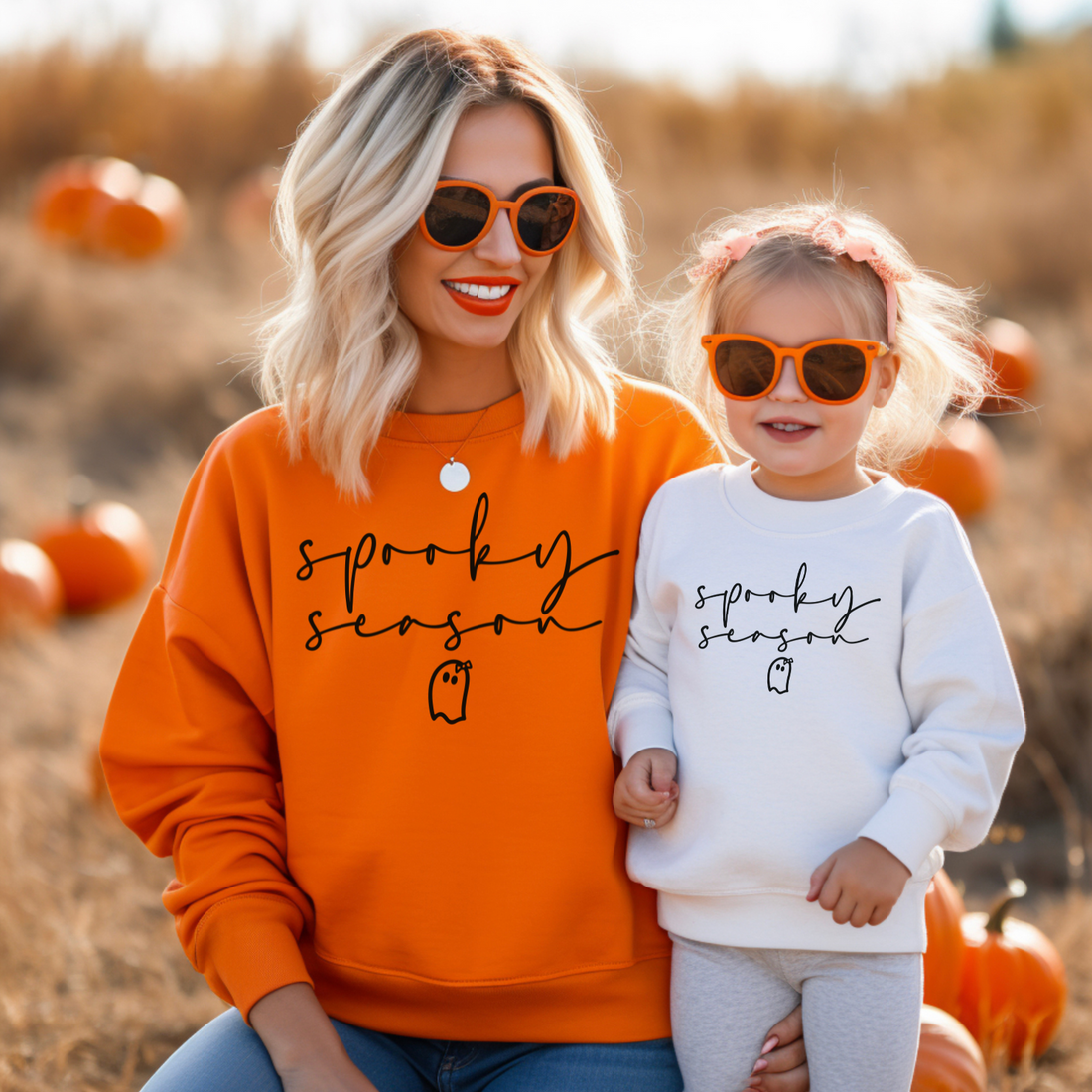 A Mother and daughter wearing matching spooky season sweatshirts