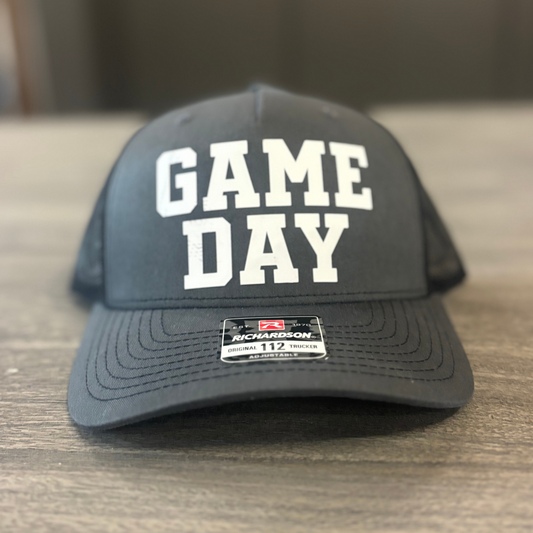 A black baseball cap with the text "GAME DAY" printed on it.