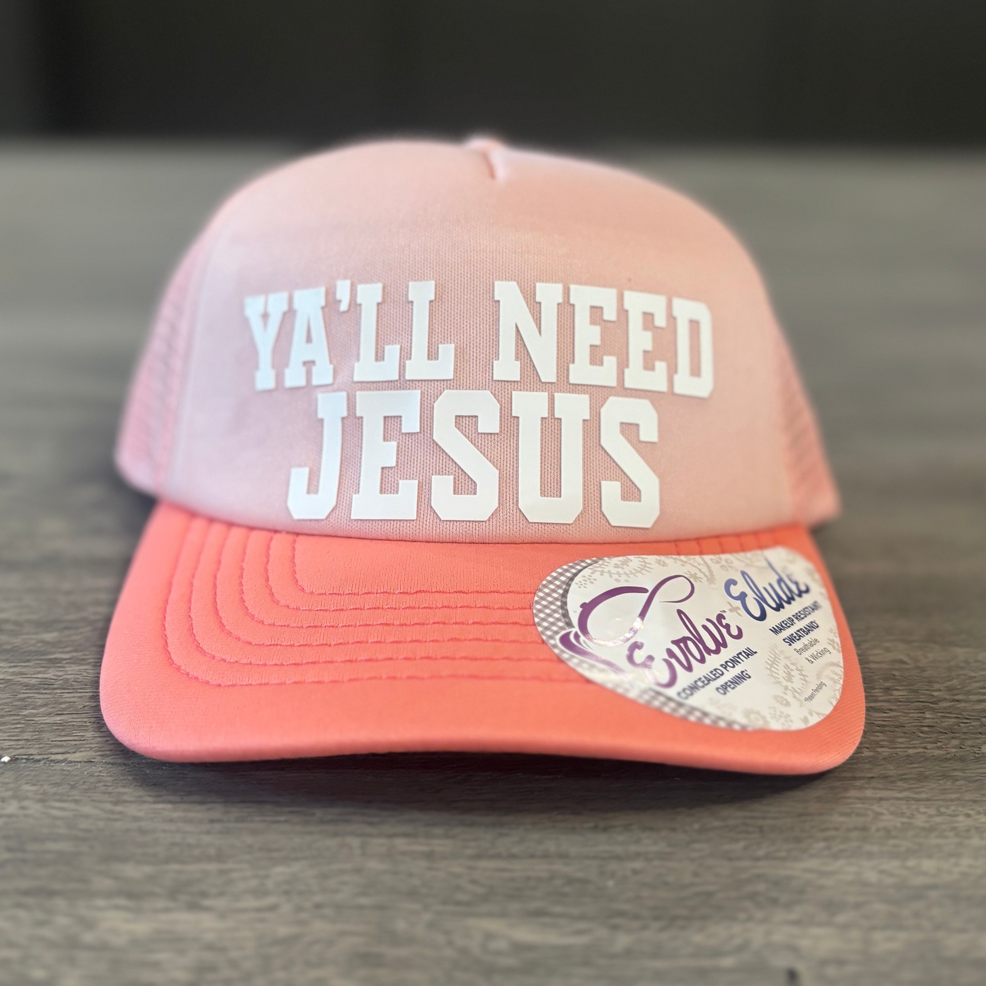 A pink baseball cap with the text "Ya'll need Jesus" printed on it.
