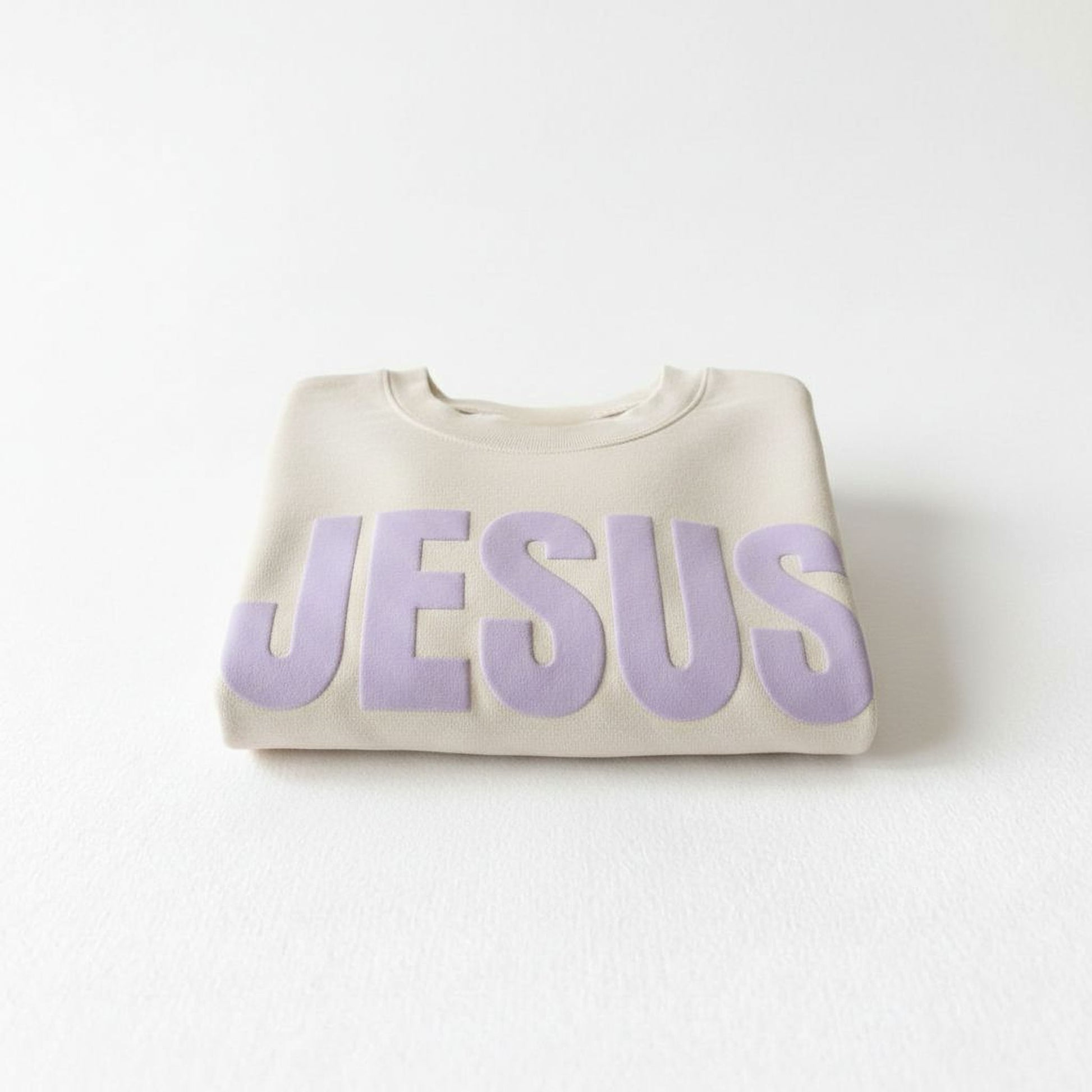 A beige sweater with the word "JESUS" printed in large purple letters.