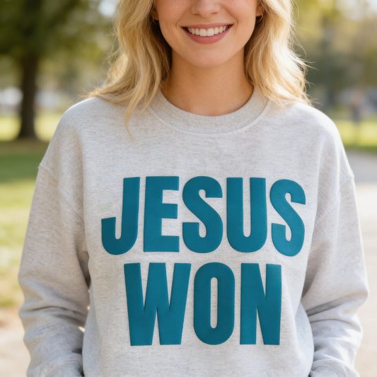 A woman wearing a grey sweatshirt with the text "JESUS WON" printed on it.