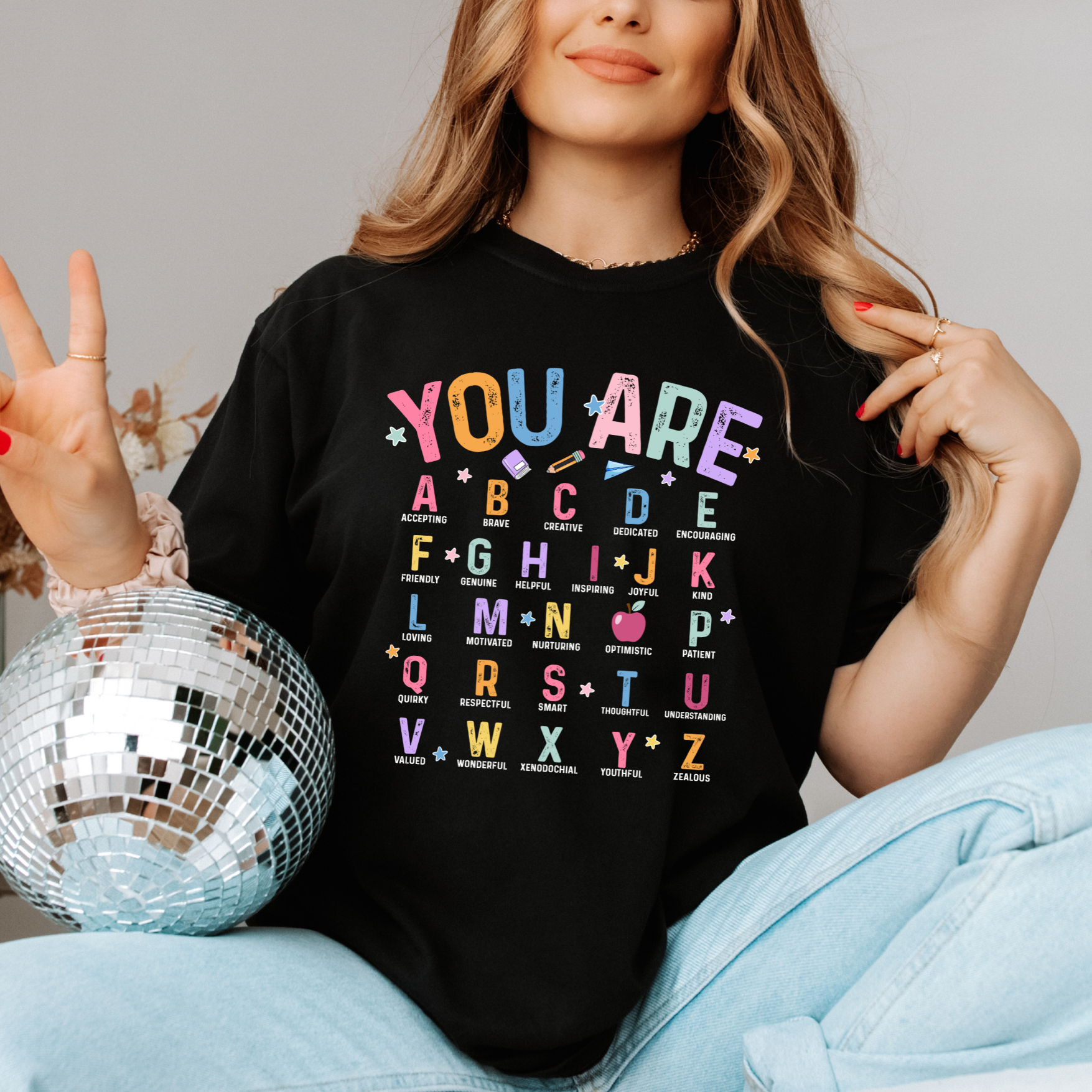 a woman sitting on a bed with a disco ball