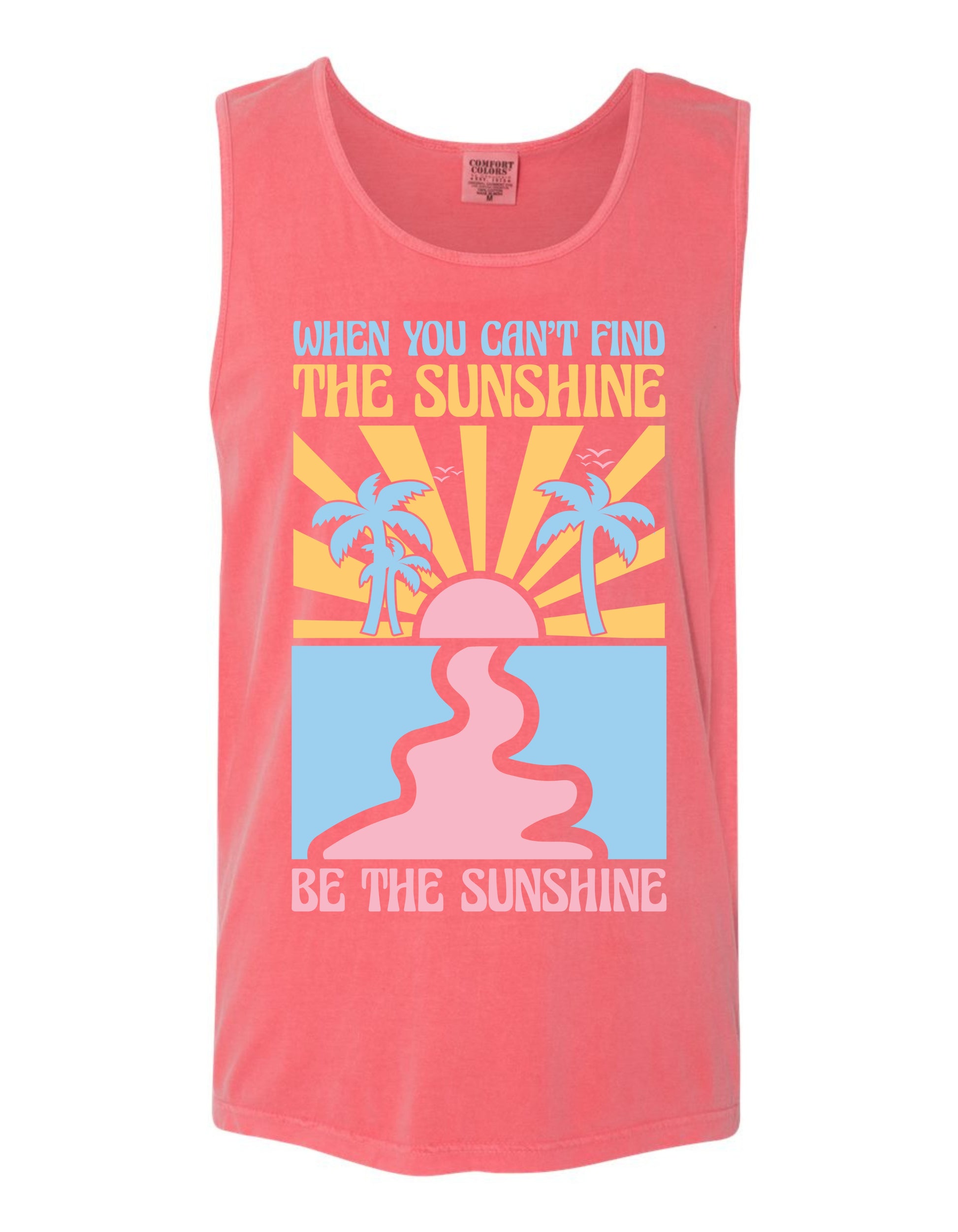 A pink tank top with a graphic design featuring a sun, palm trees, and a message that says "When you can't find the sunshine, be the sunshine".