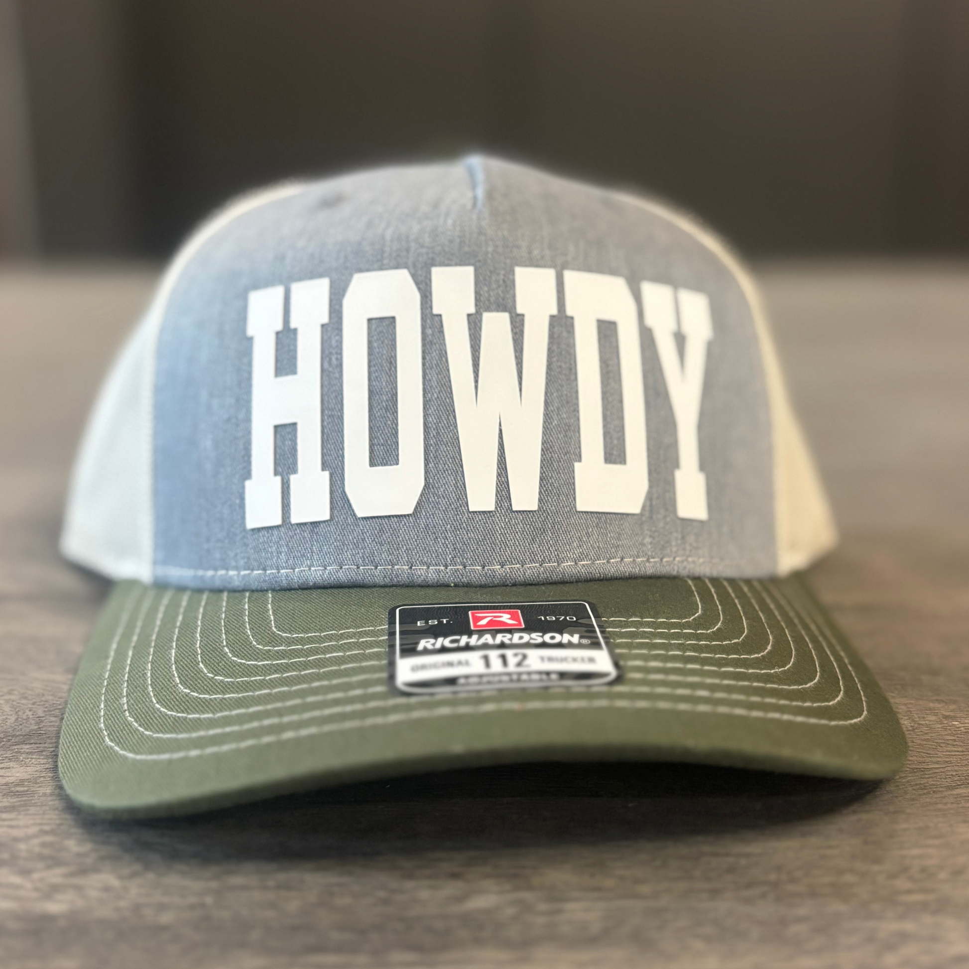 A gray and green baseball cap with the word "HOWDY" printed on it.