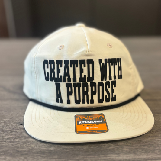 A white baseball cap with the text "CREATED WITH A PURPOSE" printed on it.