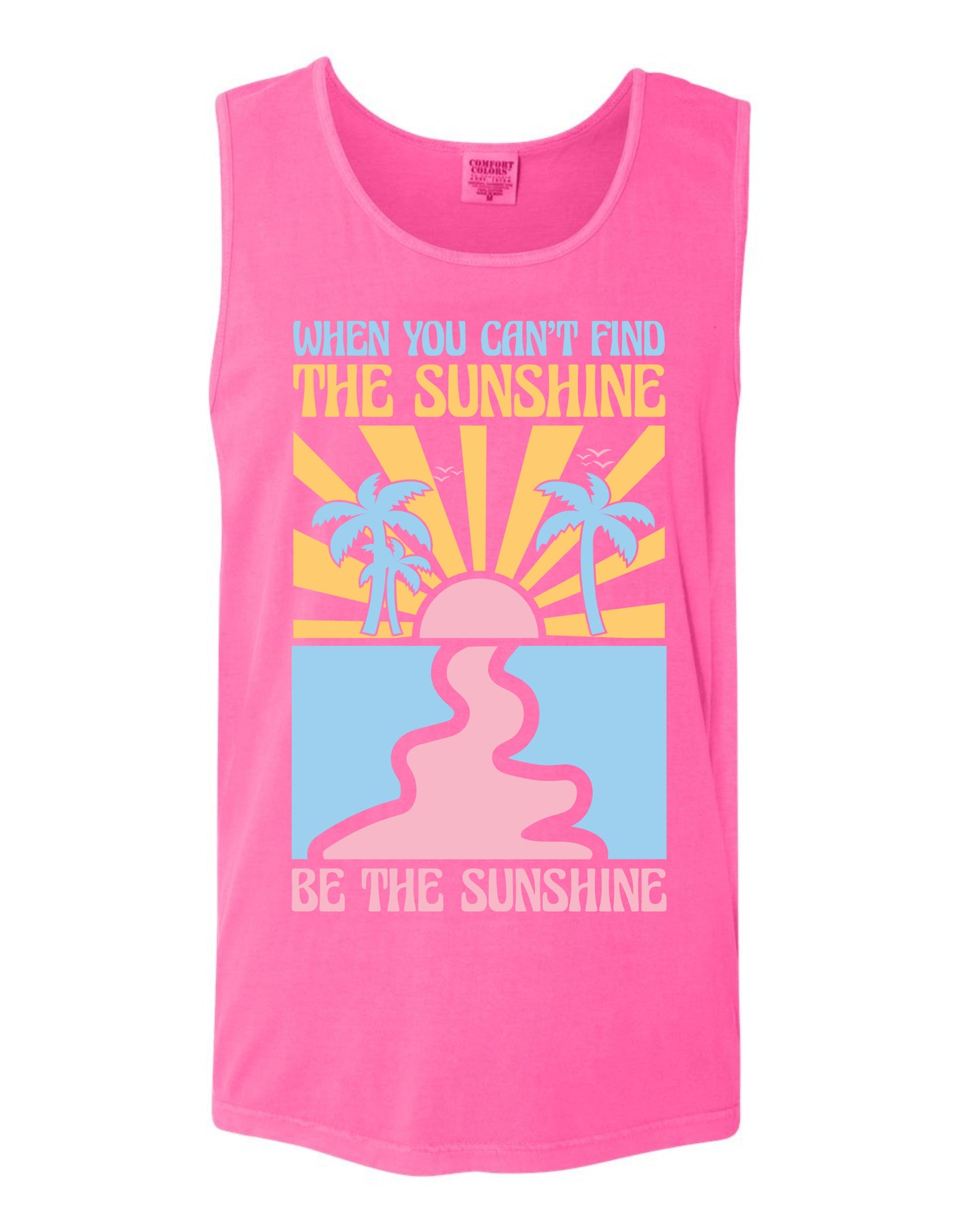 A pink tank top with a graphic design featuring a sun and palm trees, along with the text "When you can't find the sunshine, be the sunshine" printed on it.