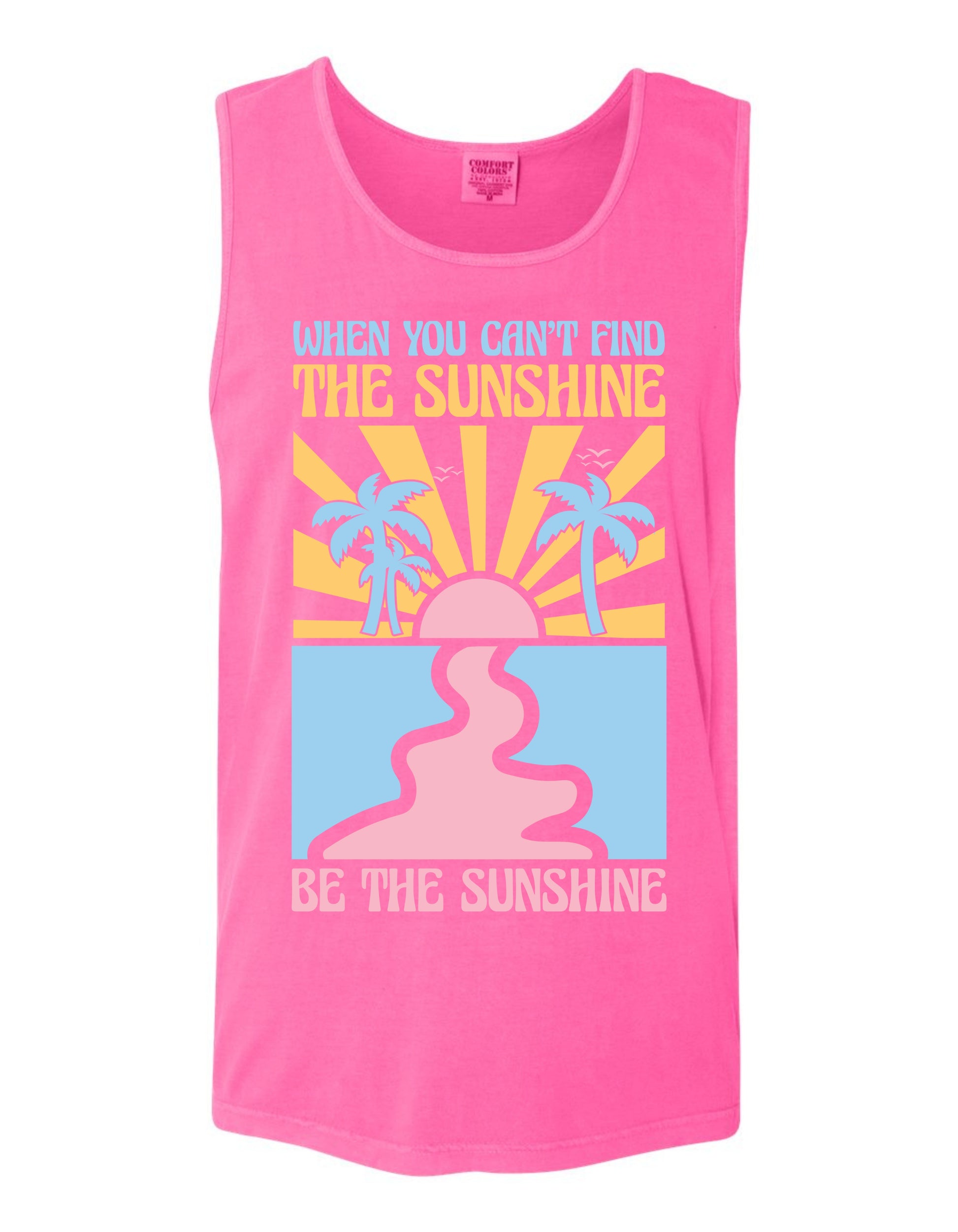 A pink tank top with a graphic design featuring a sun and palm trees, along with the text "When you can't find the sunshine, be the sunshine" printed on it.