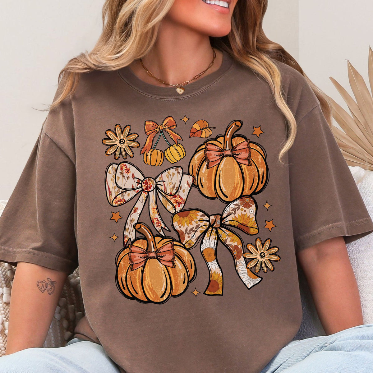 Orange pumpkins, floral bows, daisies, and stars on a Espresso T-shirt