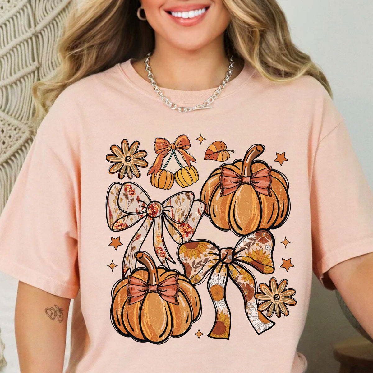 Orange pumpkins, floral bows, daisies, and stars on a Peachy T-shirt