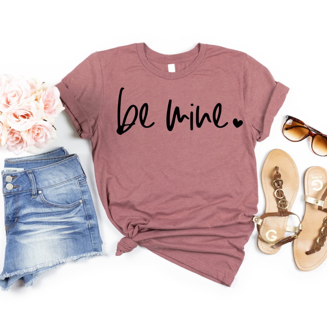 Woman wearing a Heather Mauve Be Mine graphic T-shirt