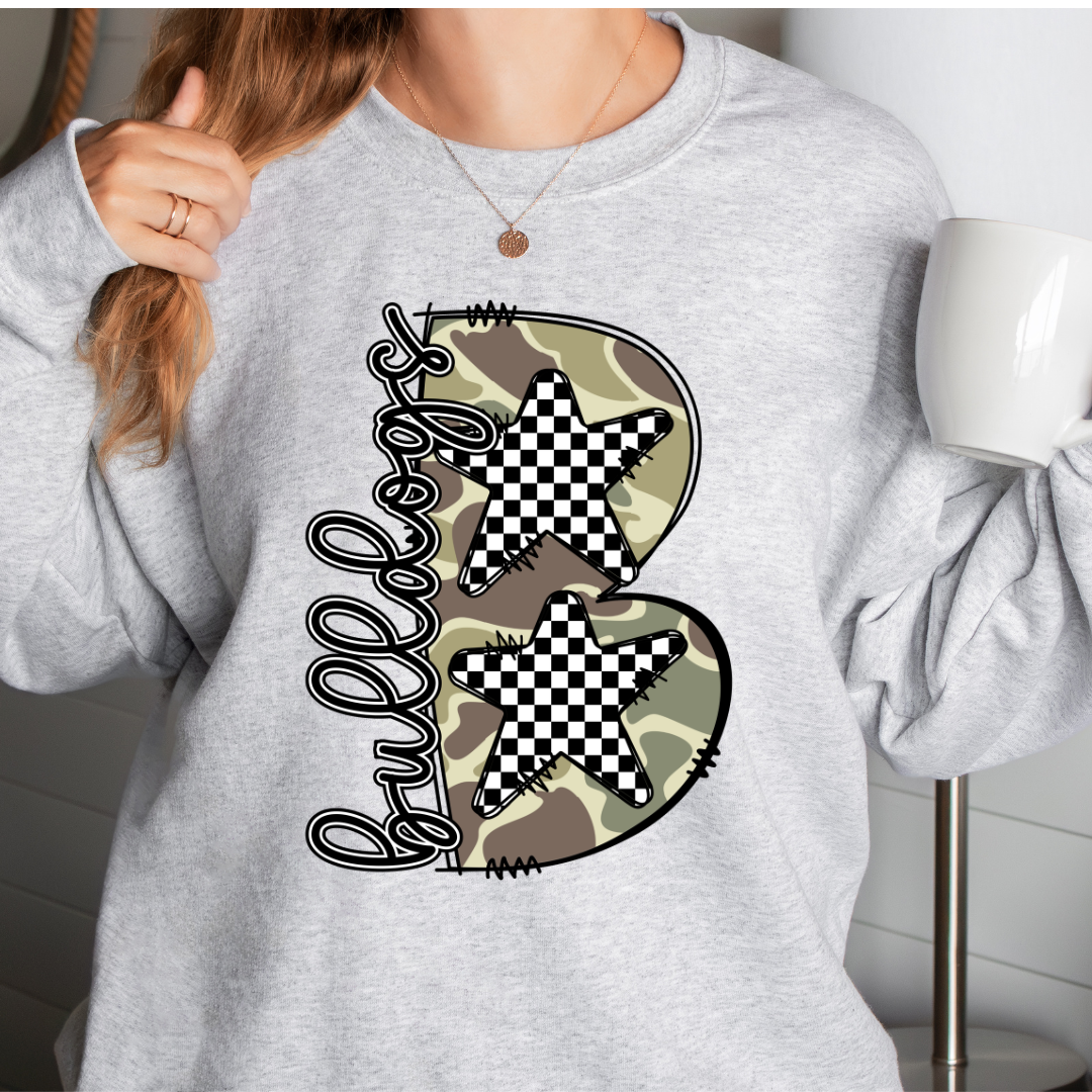 Woman wearing an Ash Bulldogs sweatshirt with camouflage B and checkered stars