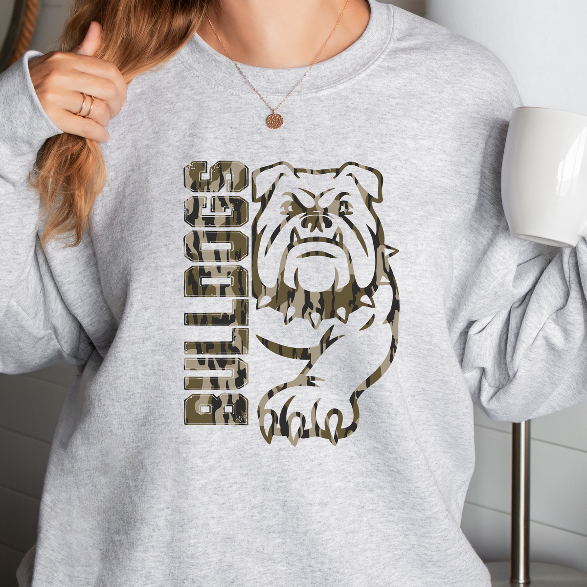 Woman wearing an Ash Camo Bulldogs full mascot sweatshirt