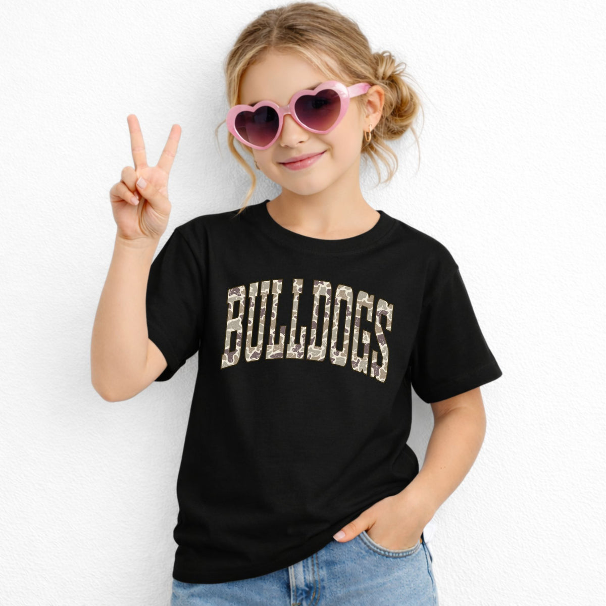 Girl wearing a Black Gildan 5000B Camo Bulldogs wordmark youth T-shirt
