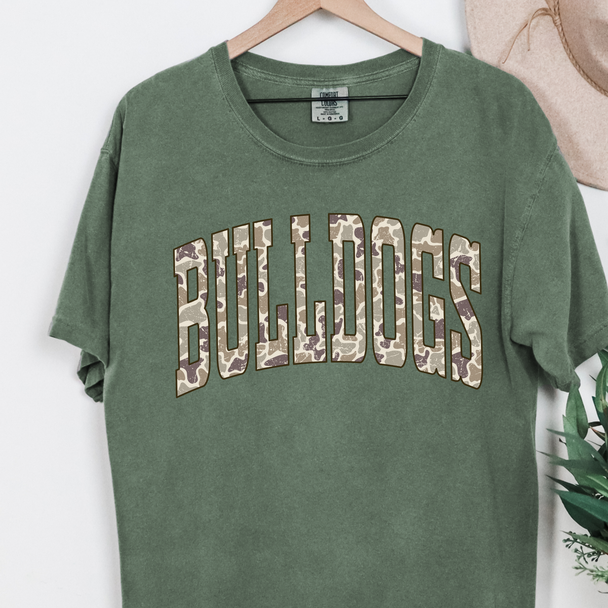 Moss Camo BULLDOGS graphic T-shirt hanging on a rack