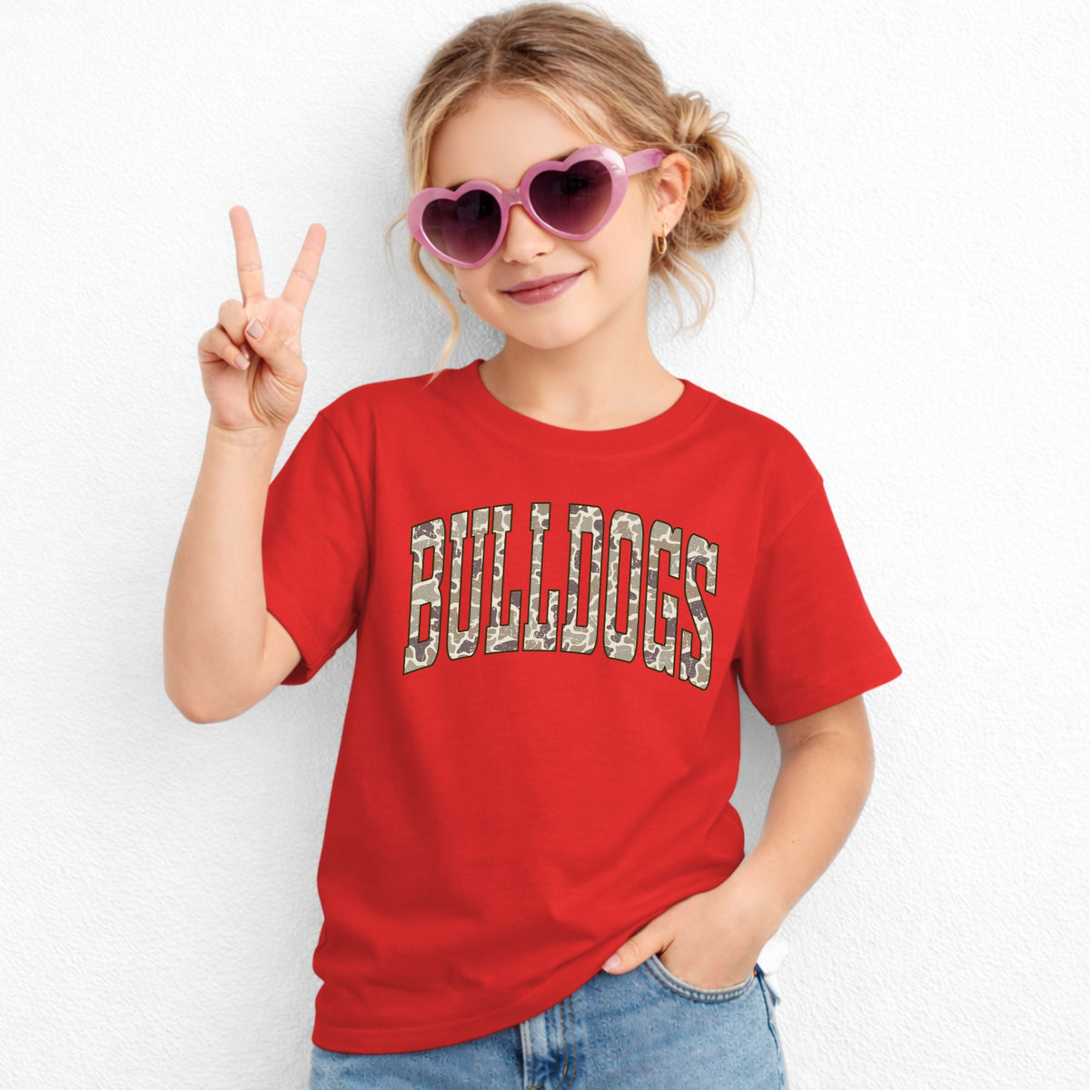 Girl wearing a Red Gildan 5000B Camo Bulldogs wordmark youth T-shirt