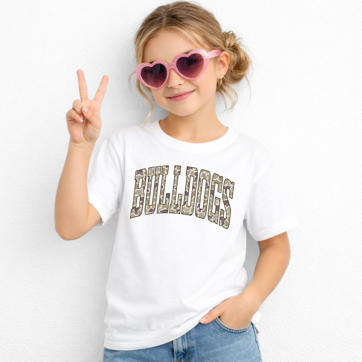 Girl wearing a White Gildan 5000B Camo Bulldogs wordmark youth T-shirt