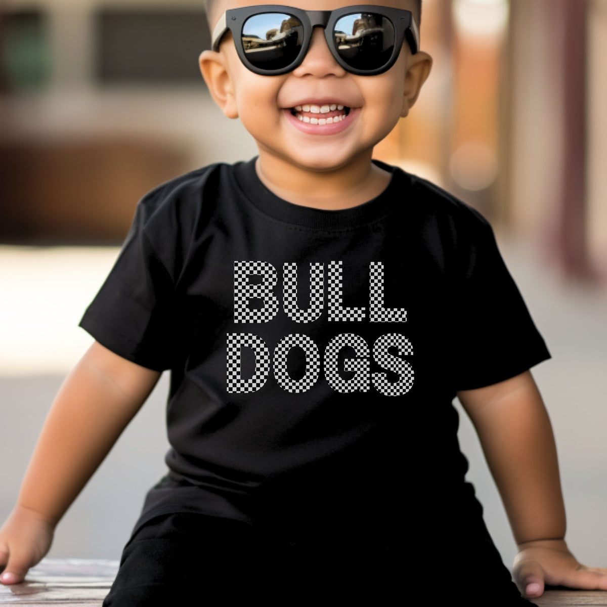 Toddler boy wearing a black Rabbit Skins 3321 Checkered Bulldogs T-shirt