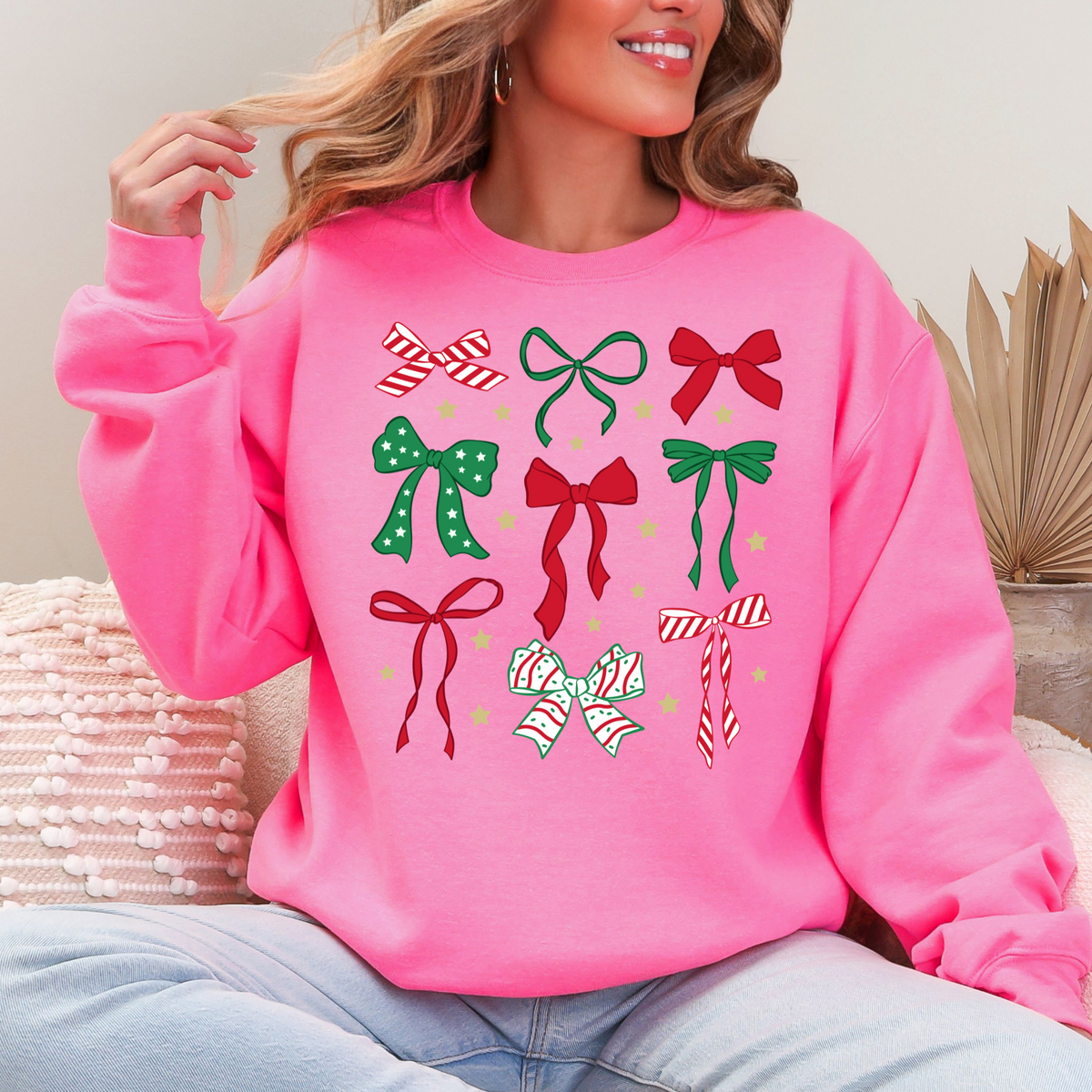 Woman wearing a safety pink sweatshirt with red and green Christmas bow designs.
