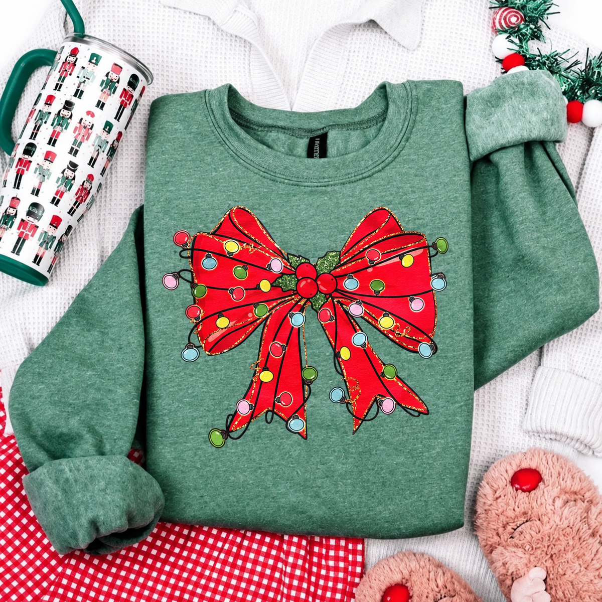 Dark heather green Gildan sweatshirt with red Christmas bow and multicolor lights, flat lay