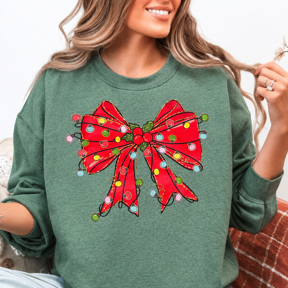 Woman wearing dark heather green Christmas bow Gildan sweatshirt with multicolor lights