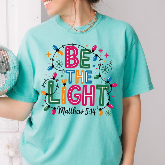 Be The Light – Matthew 5:14 Christmas Lights Comfort Colors Tee