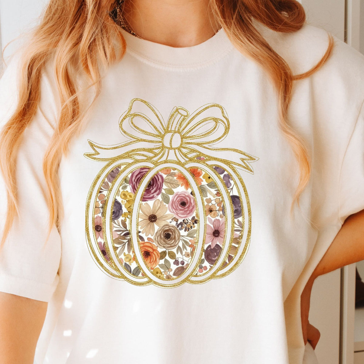 Floral pumpkin with gold-look bow design on a Ivory T-shirt