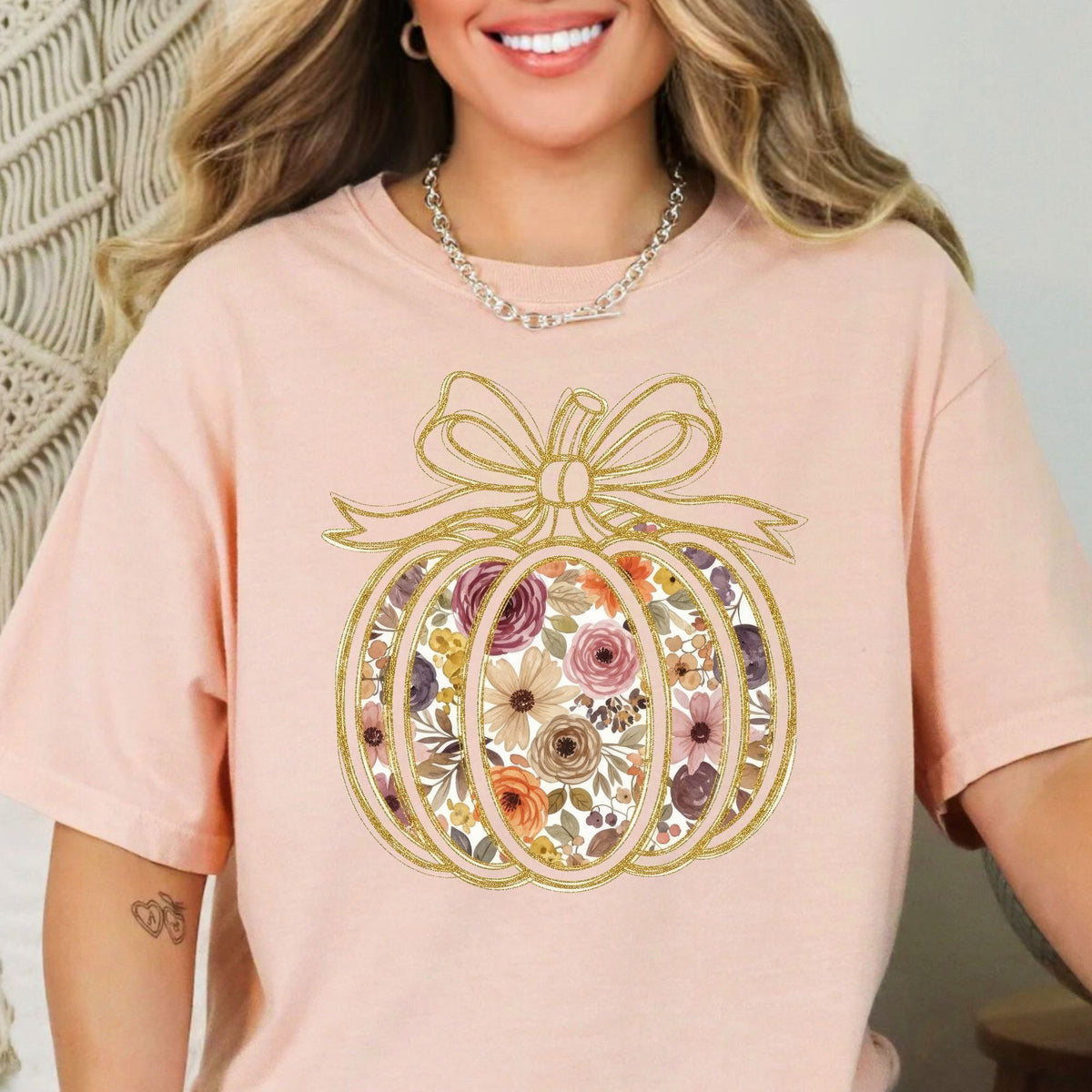 Floral pumpkin with gold-look bow design on a Peachy T-shirt