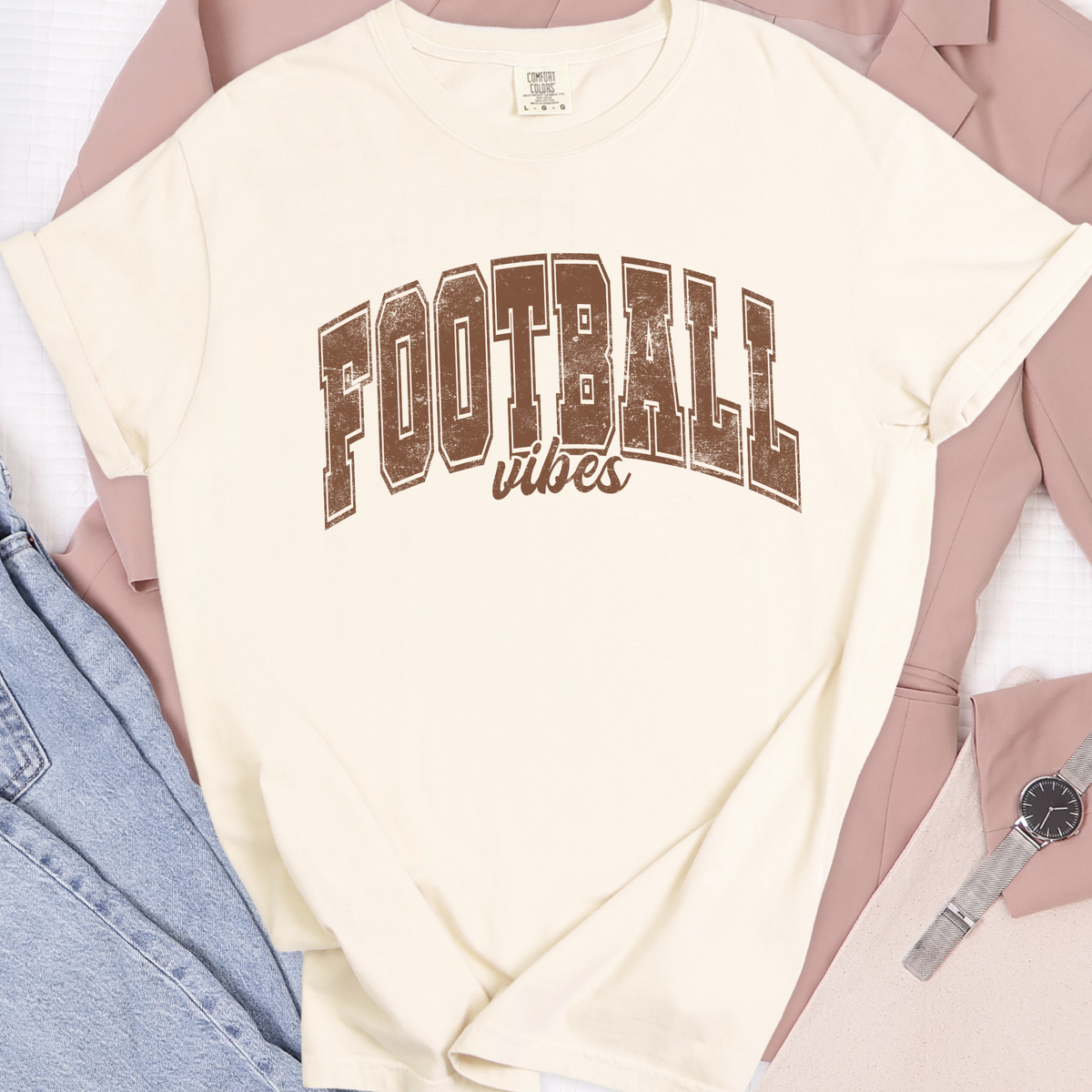 Ivory Comfort Colors 1717 T-shirt with brown Football Vibes design in a flat lay
