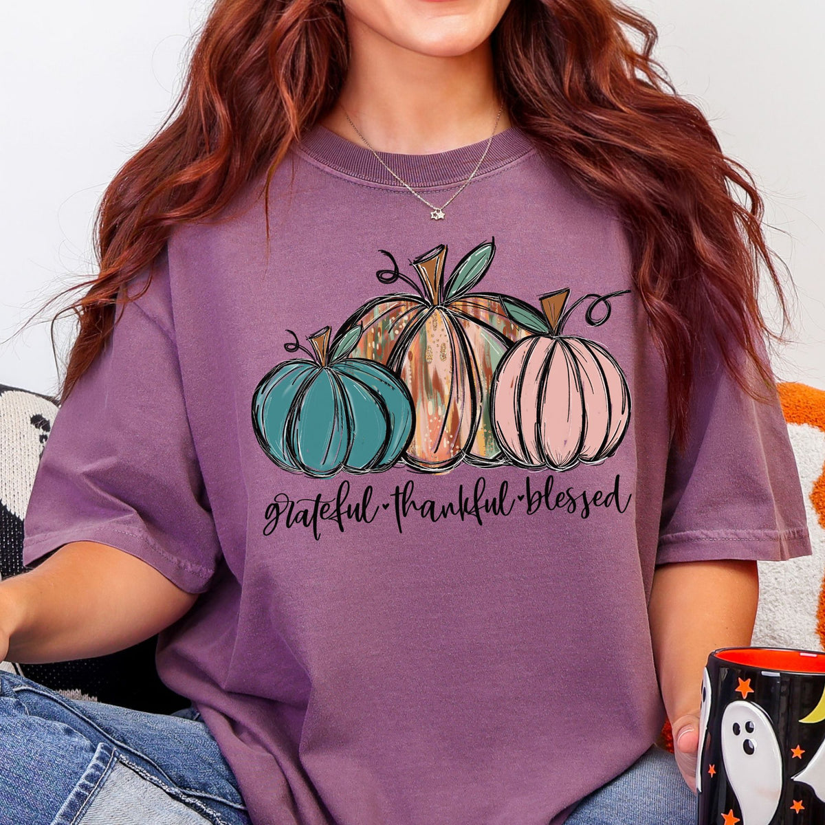 Three painted pumpkins with Grateful Thankful Blessed lettering on a Berry T-shirt