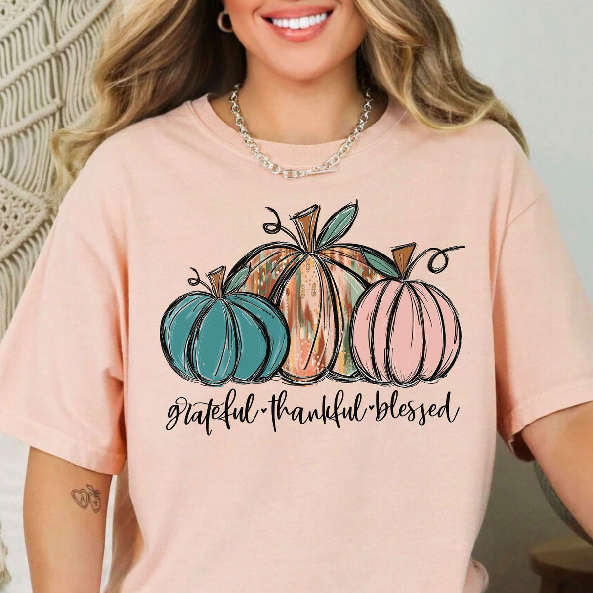 Three painted pumpkins with Grateful Thankful Blessed lettering on a Peachy T-shirt