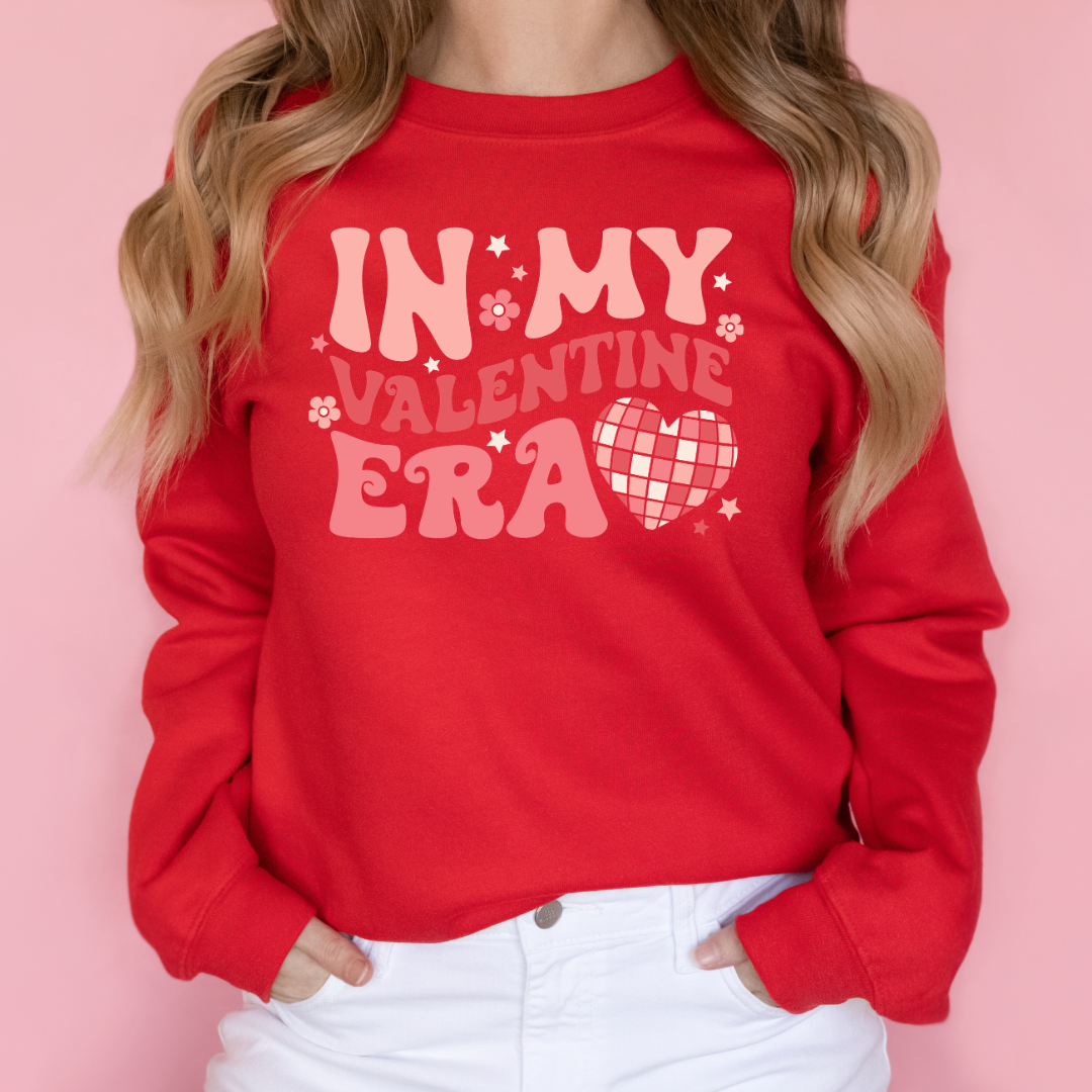 Woman wearing a red In My Valentine Era graphic sweatshirt.