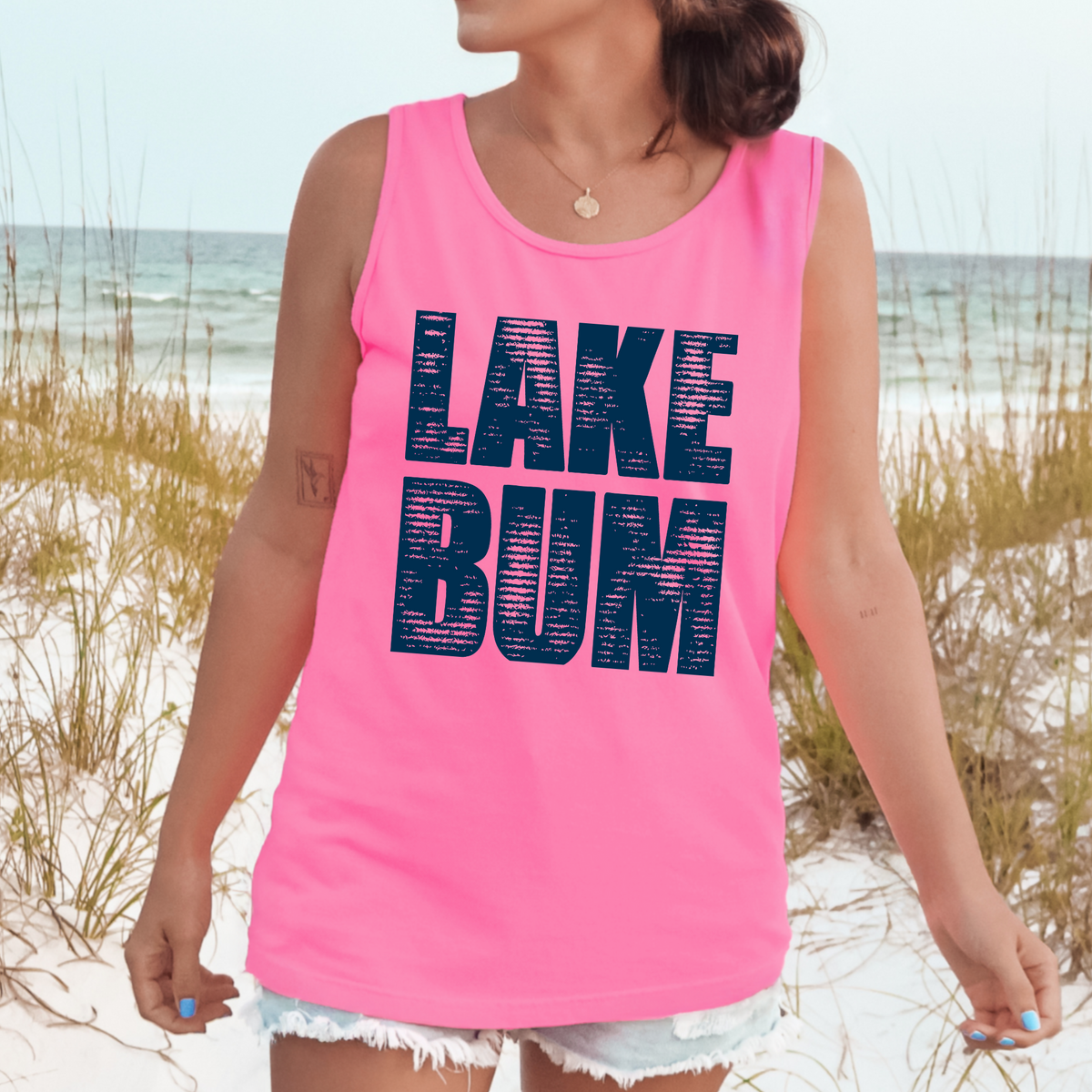 Distressed navy LAKE BUM lettering on a Neon Pink tank top.