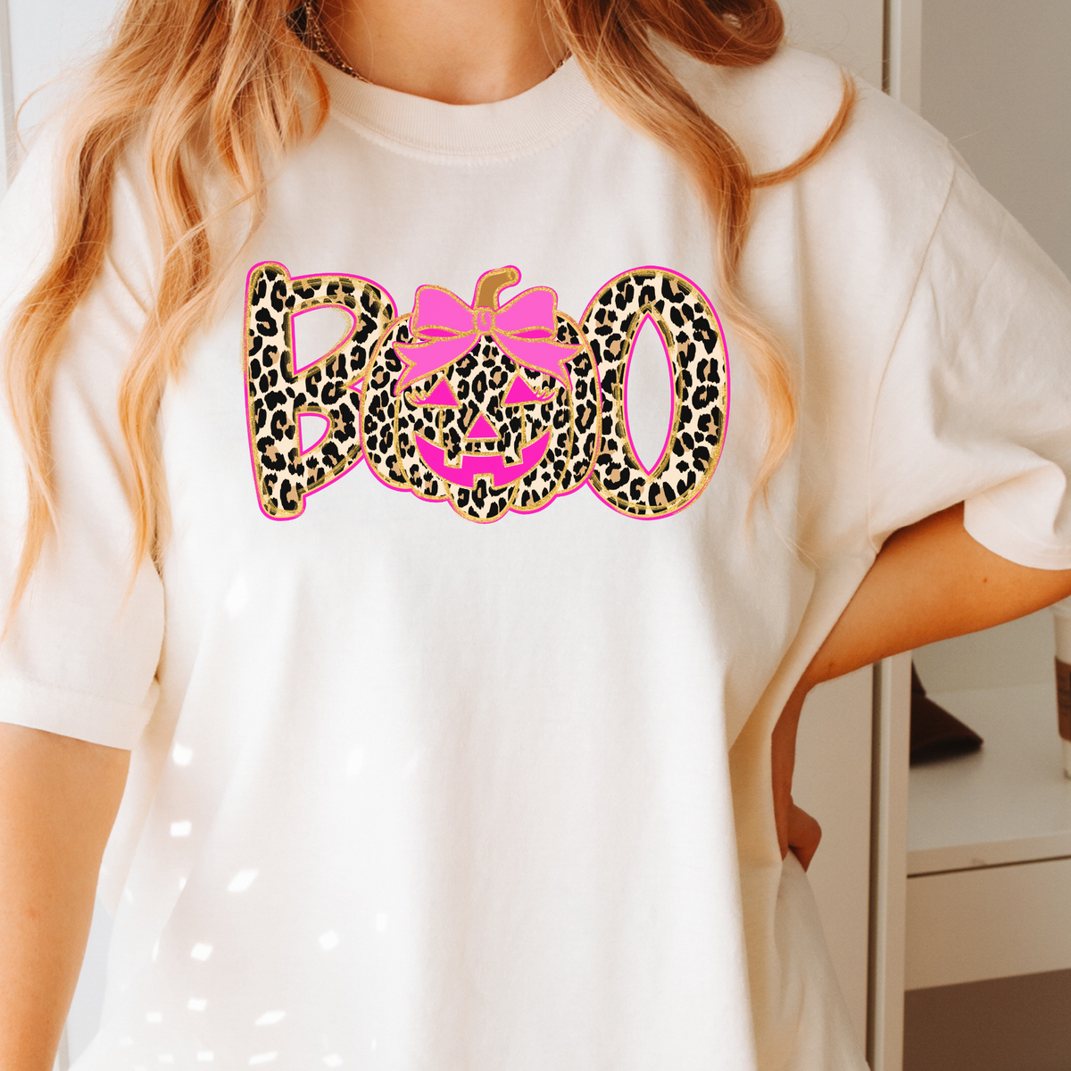 Woman wearing an Ivory leopard BOO pumpkin bow graphic T-shirt