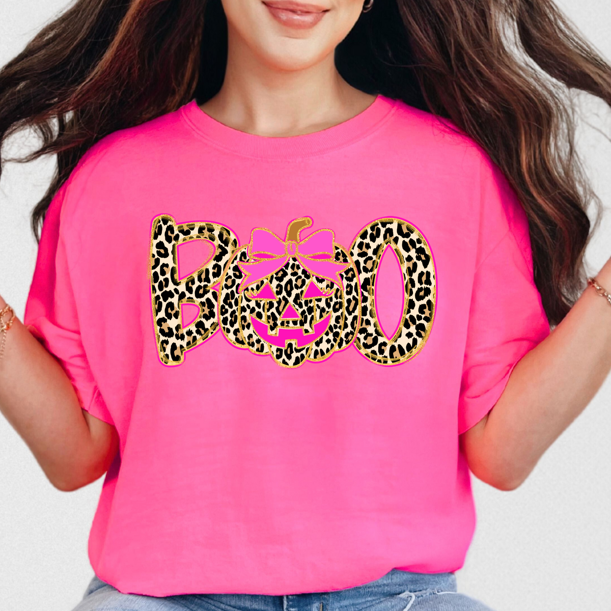 Woman wearing a Neon Pink leopard BOO pumpkin bow graphic T-shirt
