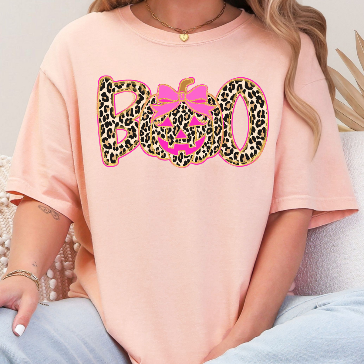 Woman wearing a Peachy leopard BOO pumpkin bow graphic T-shirt