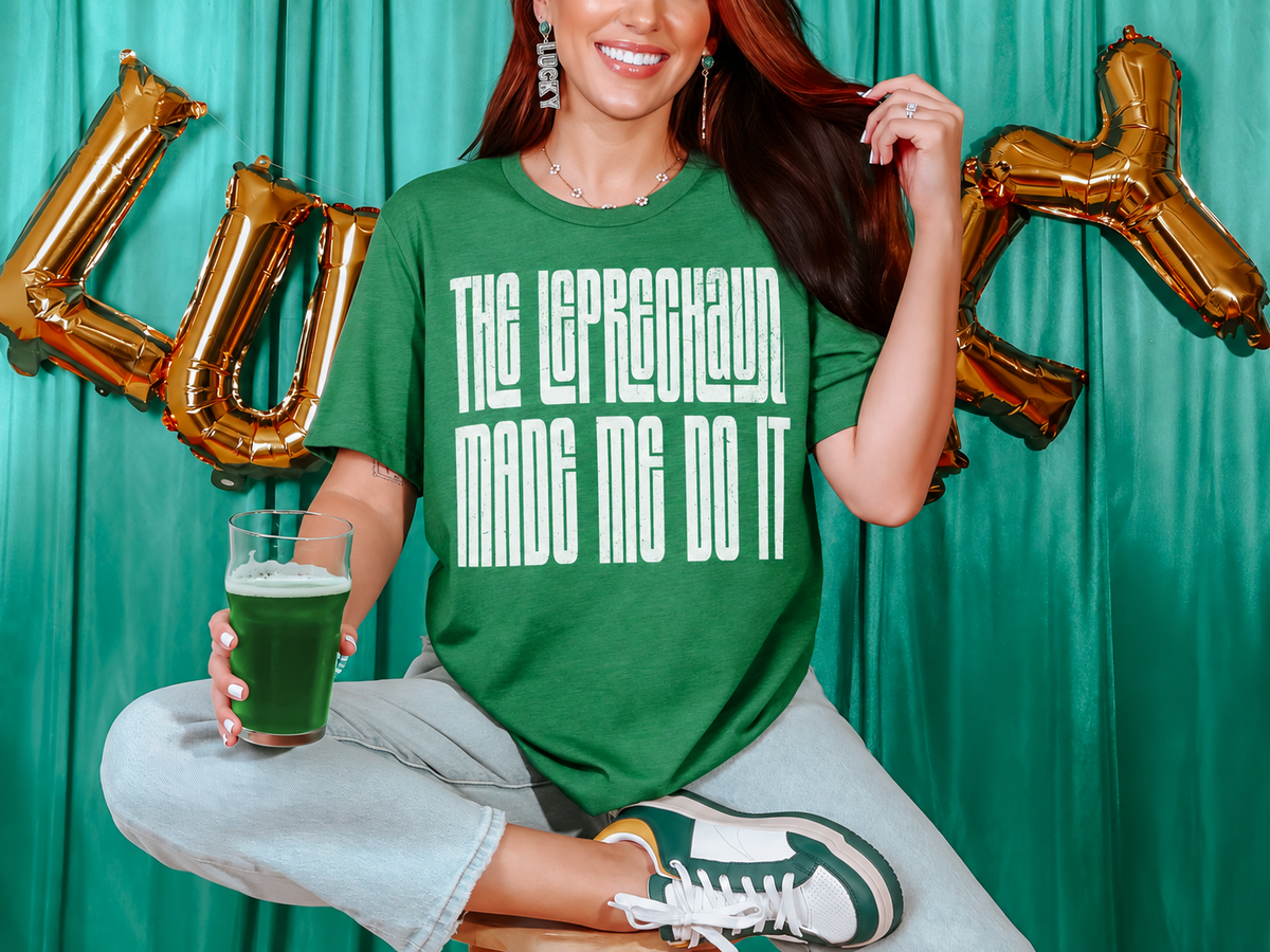 Woman wearing a Heather Grass Green shirt reading "The Leprechaun Made Me Do It."