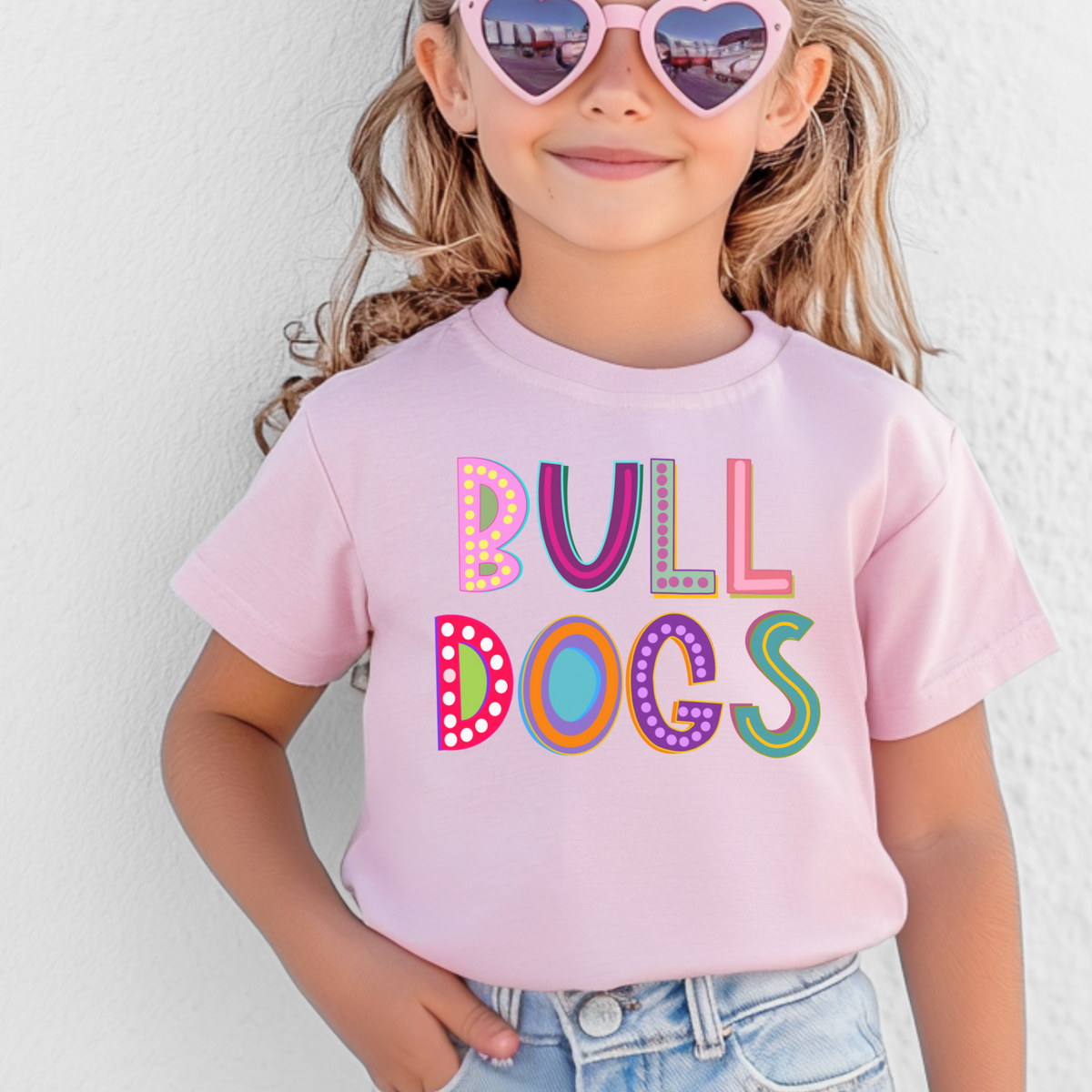 Girl wearing a Pink Bella Canvas 3001Y Marquee Bulldogs youth T-shirt