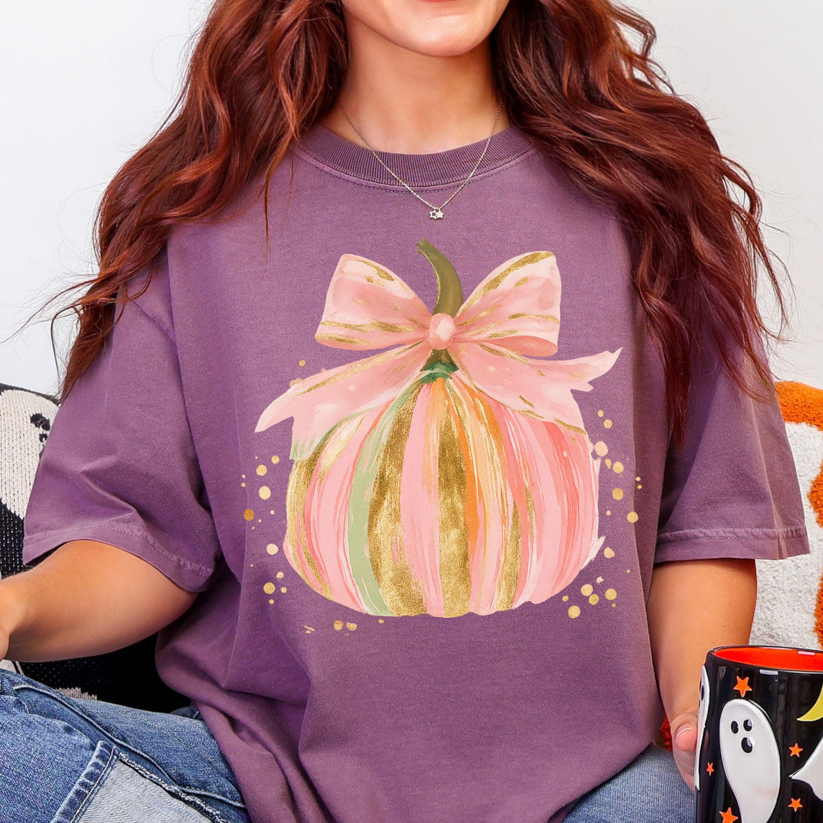 Pastel pink, orange, and green pumpkin with gold-look accents and a pink bow on a Berry T-shirt