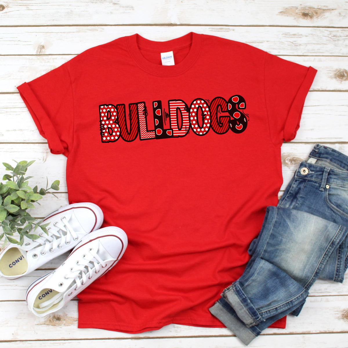 Red Gildan youth shirt with BULLDOGS in black outlined polka dot and stripe letters