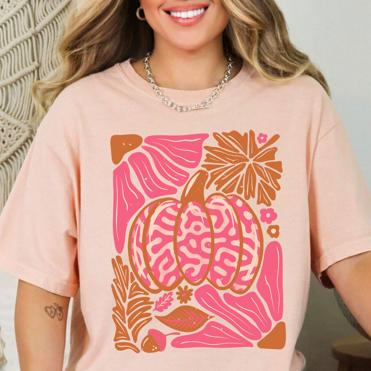 Pink patterned pumpkin with autumn leaves on a Peachy T-shirt
