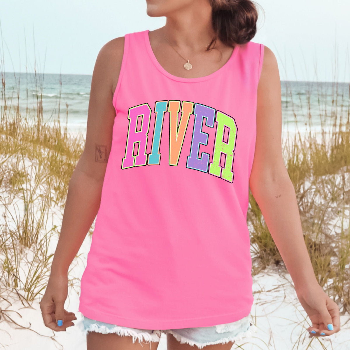 Colorful distressed RIVER lettering on a Neon Pink tank top.