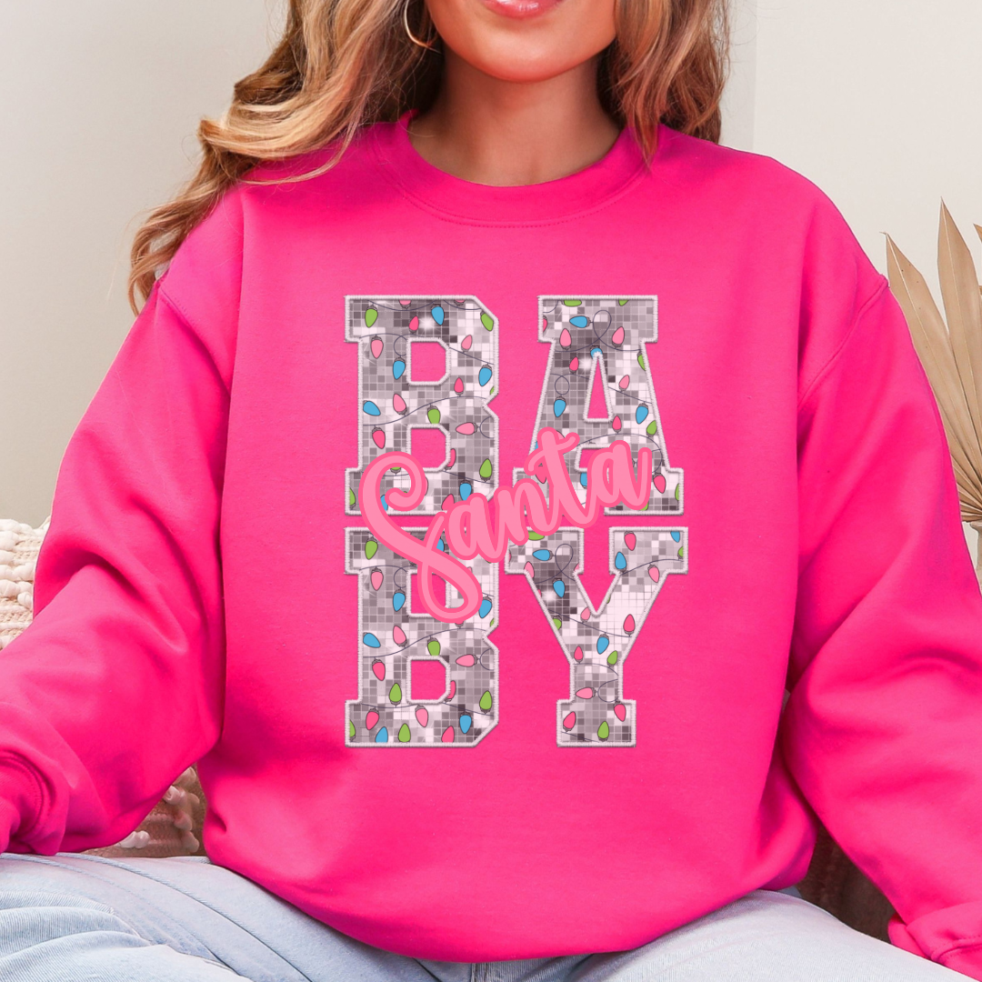 Woman wearing a heliconia sweatshirt with a Santa Baby Christmas lights design.