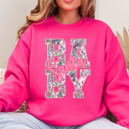 Woman wearing a heliconia sweatshirt with a Santa Baby Christmas lights design.