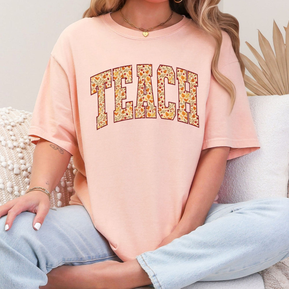 Woman wearing a Peachy TEACH fall leaves graphic T-shirt
