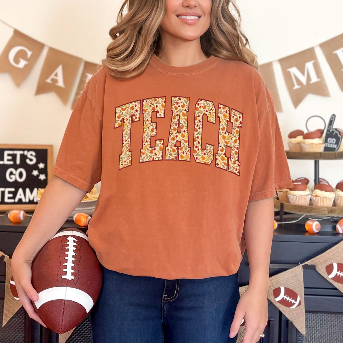 Woman wearing a Yam TEACH fall leaves graphic T-shirt