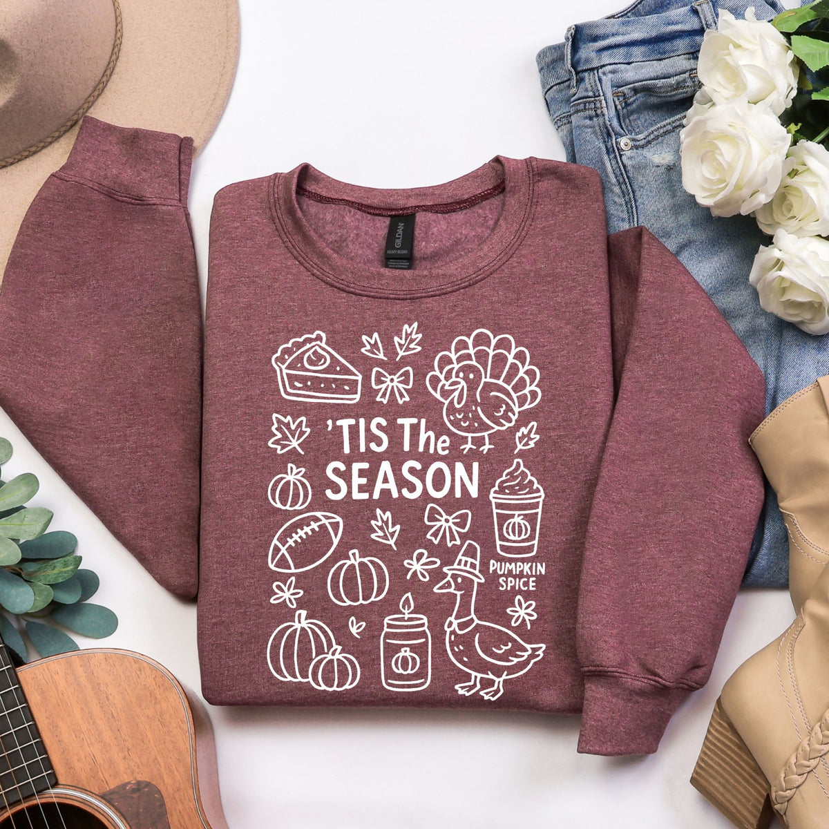 Woman wearing a Heather Maroon 'Tis the Season Thanksgiving sweatshirt with white doodle artwork.