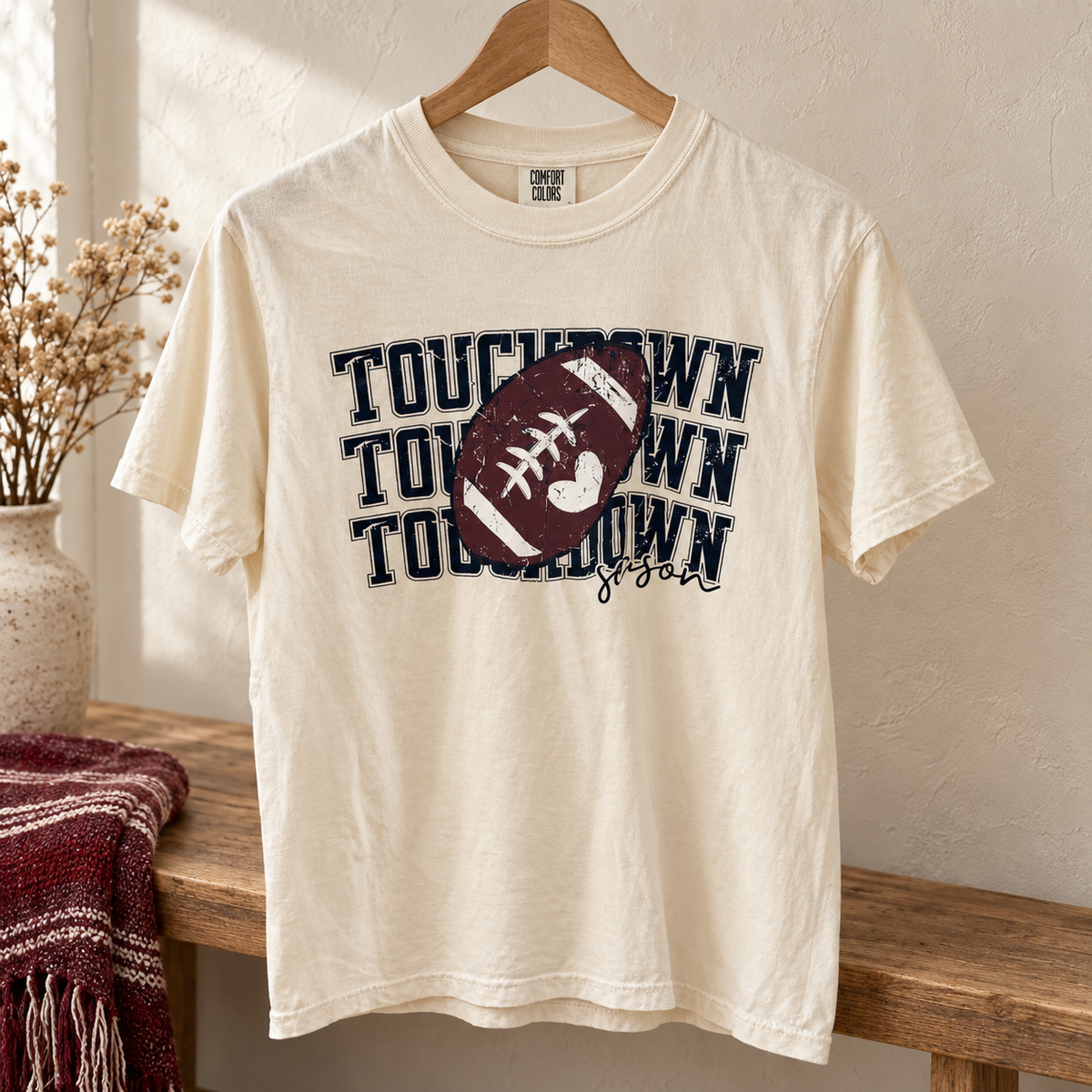 Ivory Comfort Colors Touchdown Season football shirt on wooden hanger
