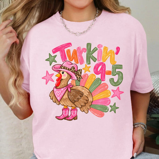 Cowgirl turkey in pink boots with Turkin’ 9–5 lettering on a Blossom T-shirt