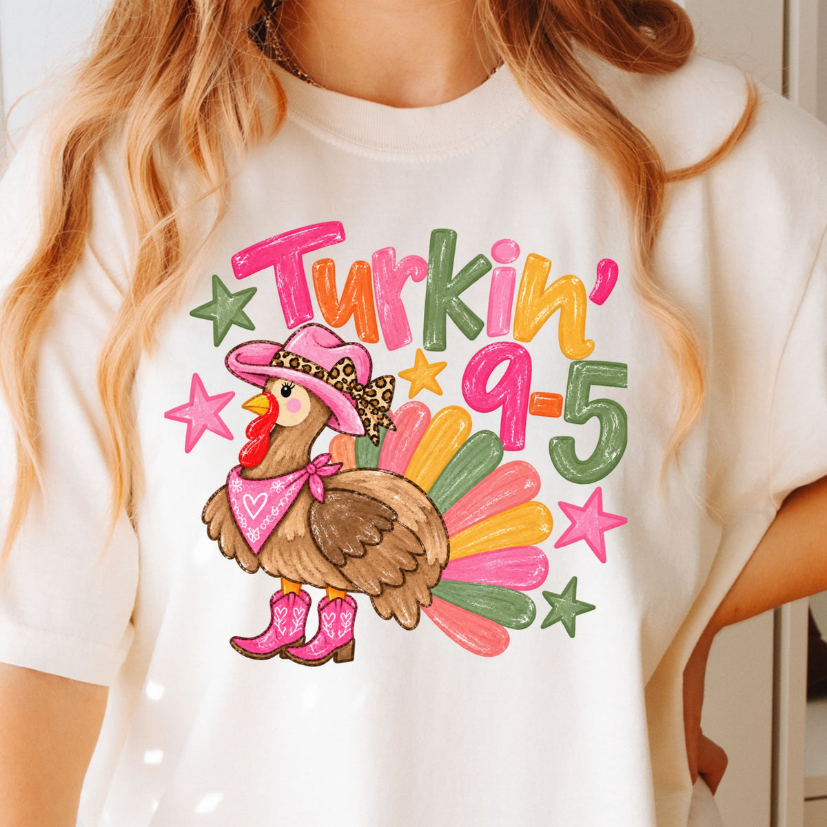 Cowgirl turkey in pink boots with Turkin’ 9–5 lettering on a Ivory T-shirt